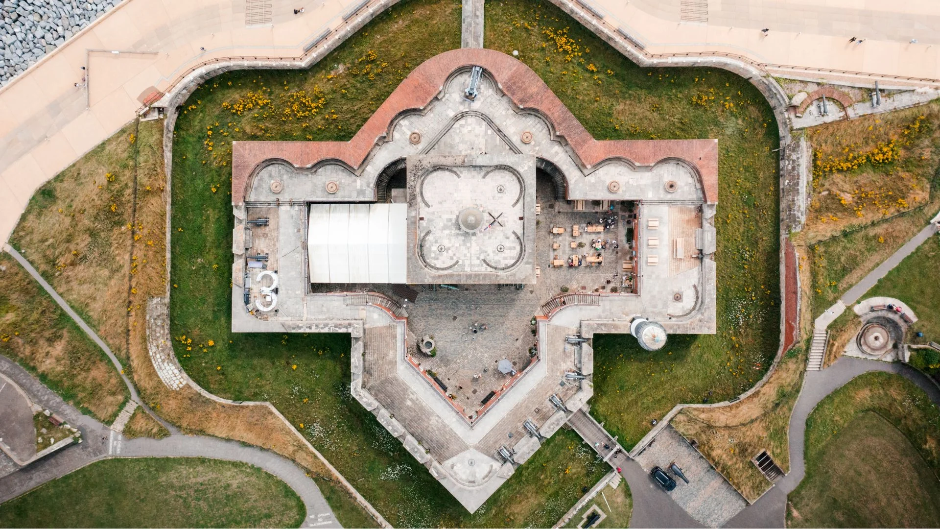 Aerial photograph of a star-shaped stone fort surrounded by green grass and water.