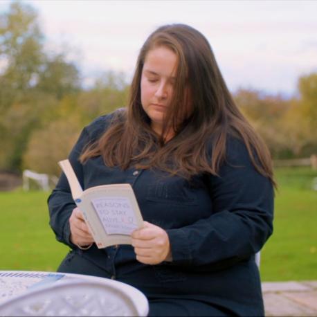 Amy sat outside reading a book
