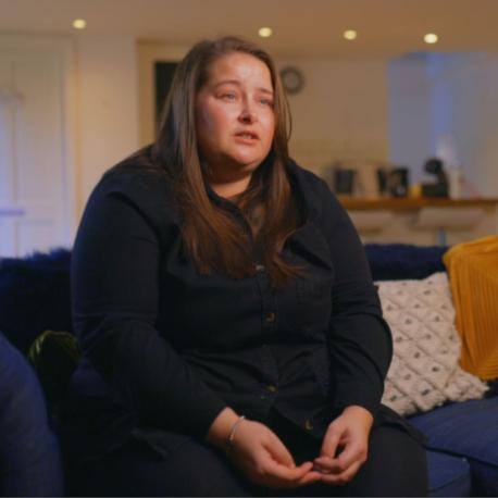 Amy sat on a sofa filming an interview