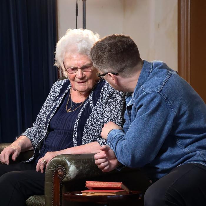 Filmmaker talking to female interviewee in arm chair