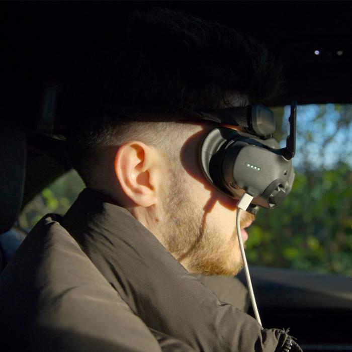 close up photography of Rob sat in a car wearing a drone headset
