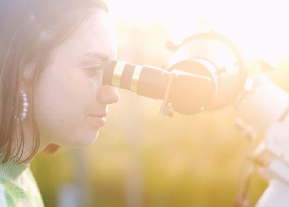 Lady looking into microscope in the sunshine