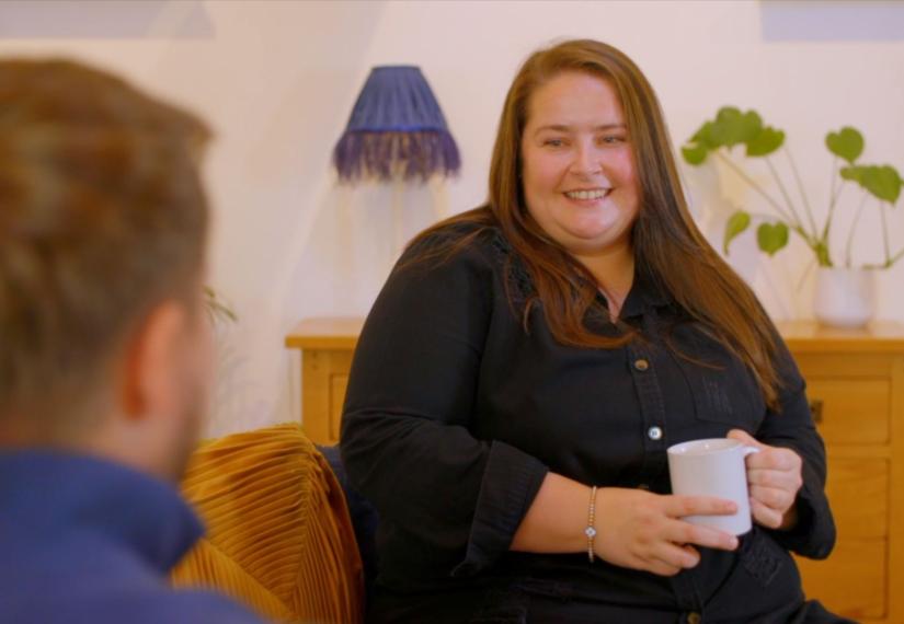 Amy saw on a sofa laughing with a friend