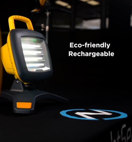 A yellow and grey portable LED work light on a dark surface.