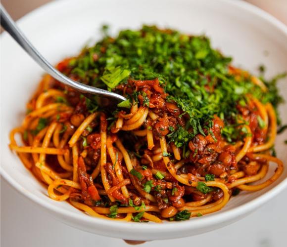 Spaghetti bolognese in a bowl with some wrapped around a fork
