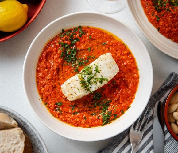Bowl with fish and tomato sauce on a counter top
