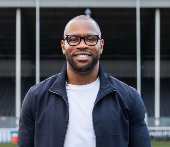 Headshot of rugby player with pitch in the background