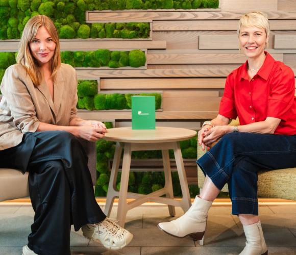 Two people sat at a table smiling at the camera