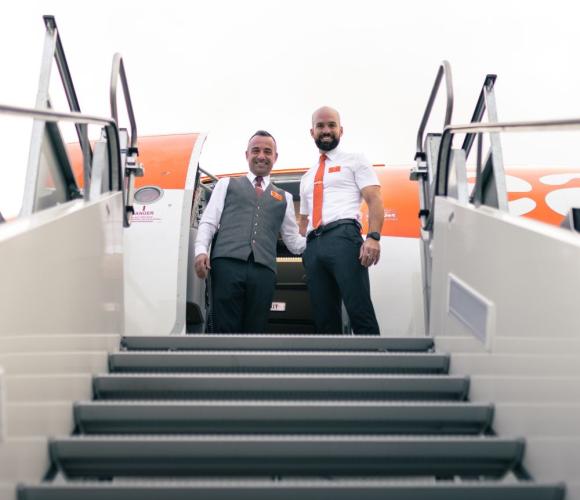 easyjet staff at the top of the place stairs smiling down at the camera