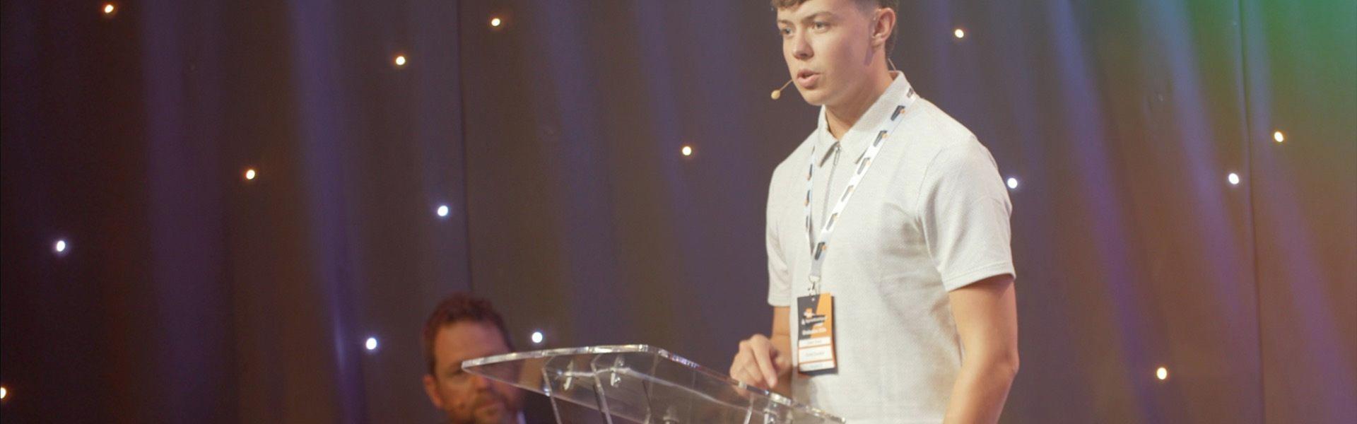 Young man receiving an award on stage at an event