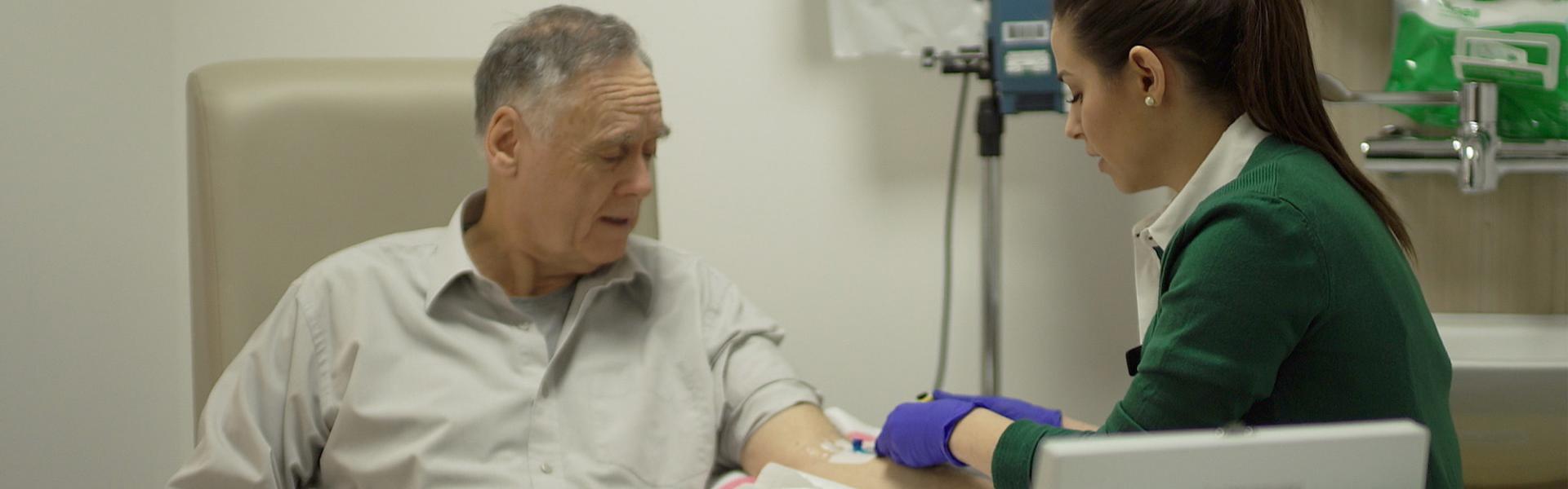 Man receiving medical care in a hospital from a female nurse