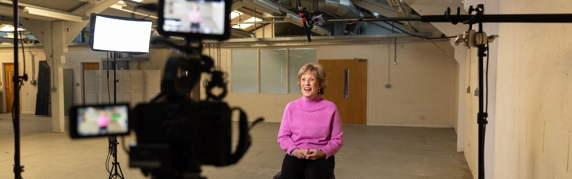 Lady being interviewed in factory on camera