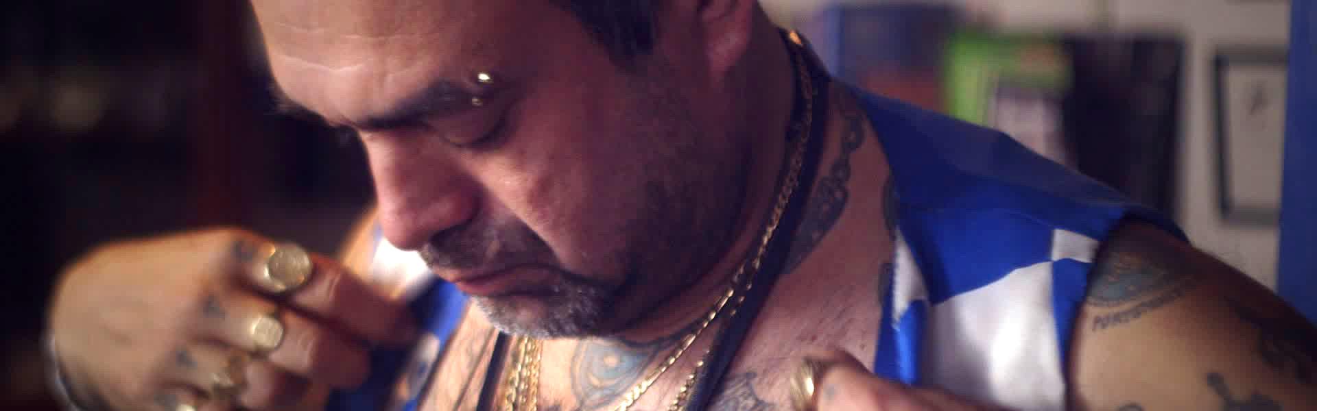Football fan with tattoos putting on clothes