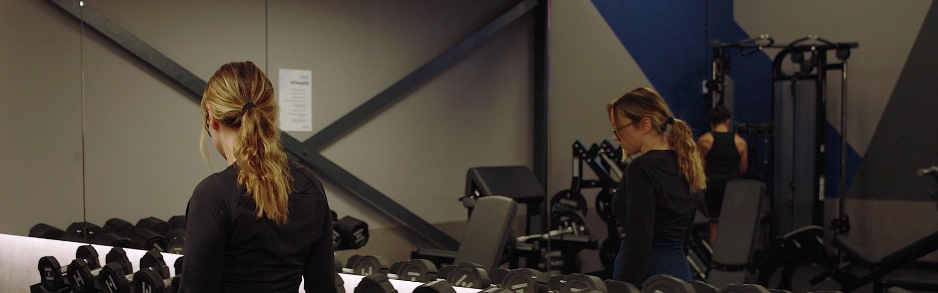 Women walking in a gym looking at the equipment