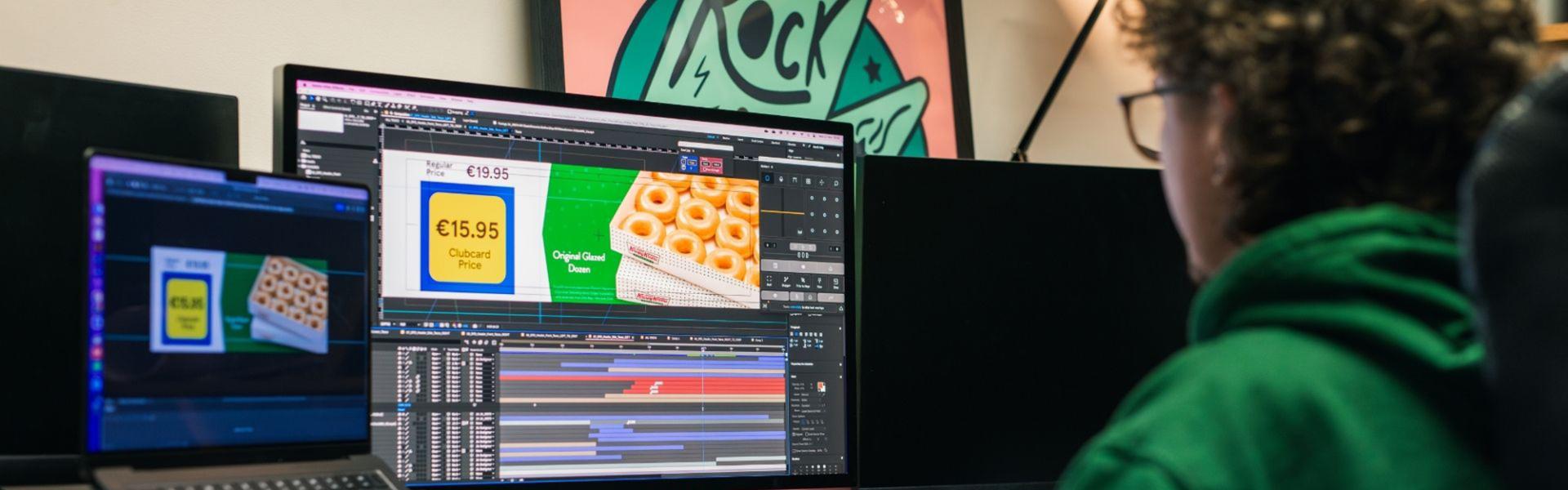 Person in green hoodie editing video with Lidl graphics on multiple screens.