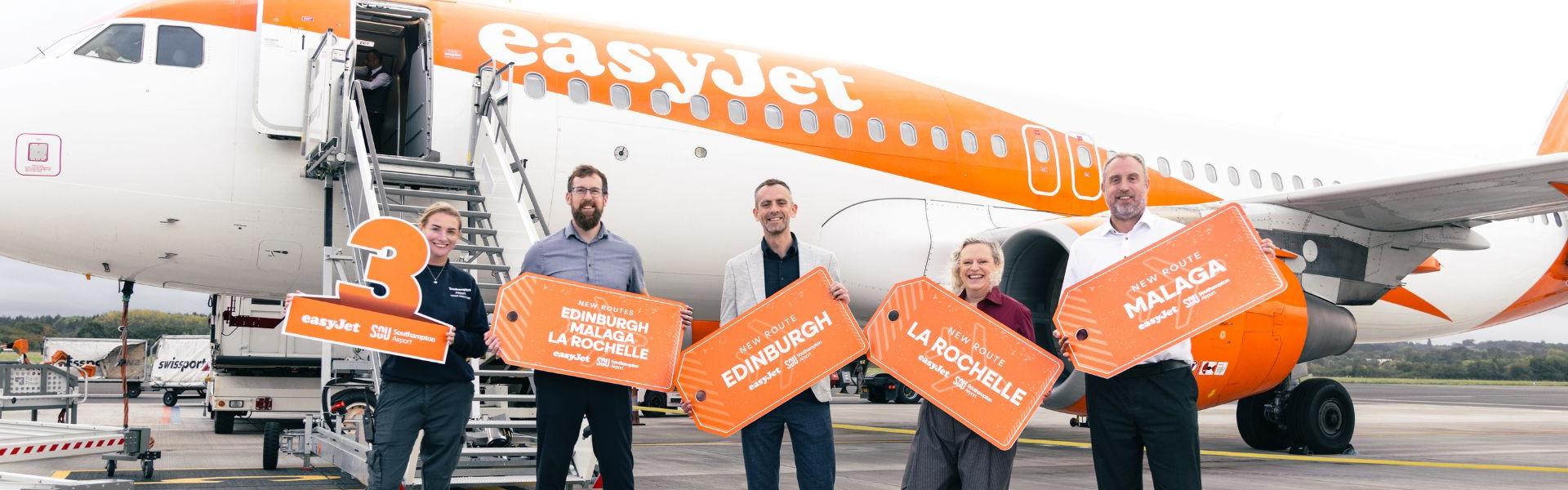 Staff at Southampton Airport and easyJet holding signs announcing three new routes